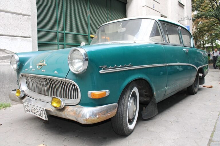 Teal 1950s Opel Rekord parked on a city street.