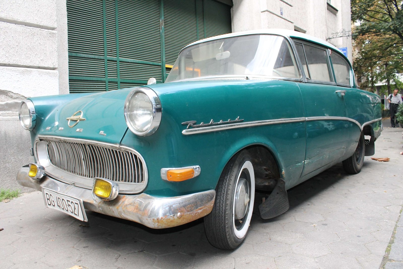 Teal 1950s Opel Rekord parked on a city street.